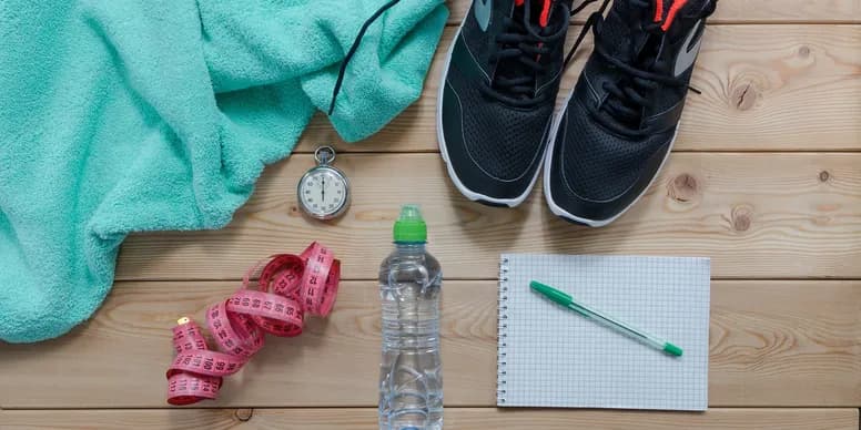Fitness assessment tools including measuring tape, stopwatch, notebook, and training gear